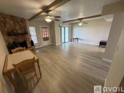 A living room with a stone fireplace and wooden furniture.