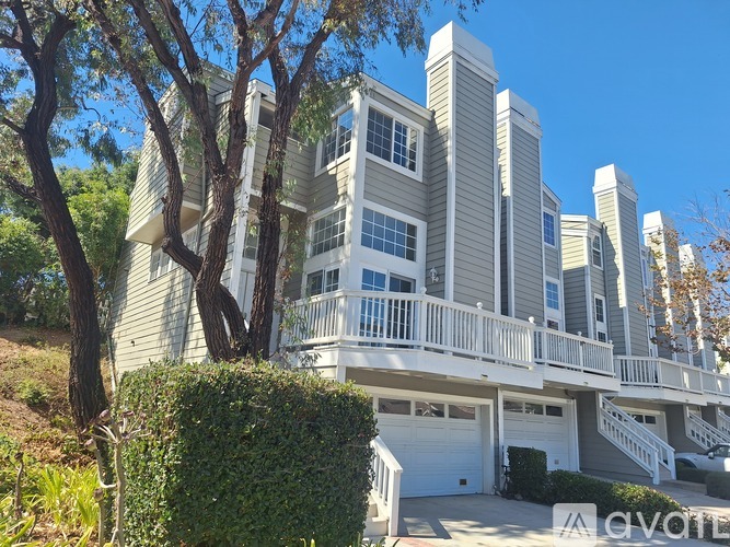 A modern multi-story residential building with balconies and garages.