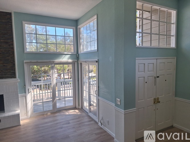 A room with a fireplace and a door leading to a balcony.