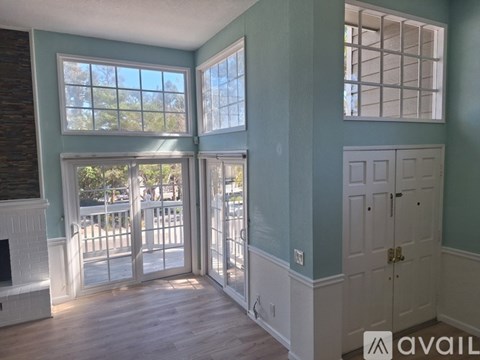 A room with a fireplace and a door leading to a balcony.