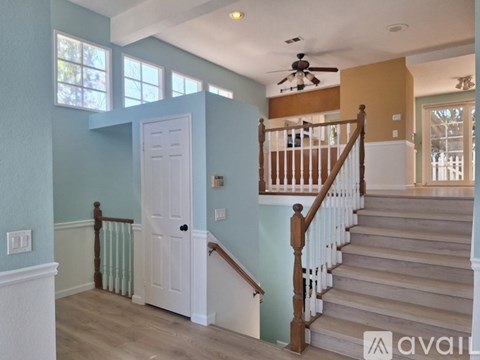 A staircase with a wooden banister and a white door.