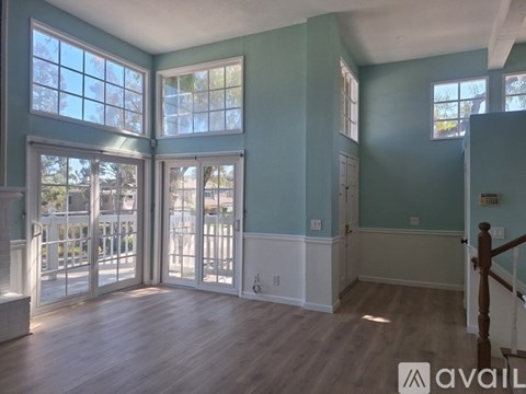 A room with a large window and a wooden floor.