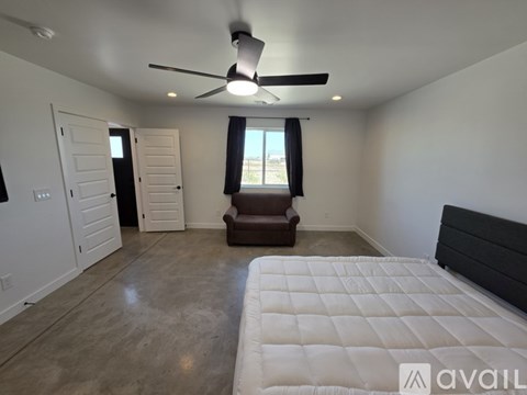 A bedroom with a large bed and a ceiling fan.