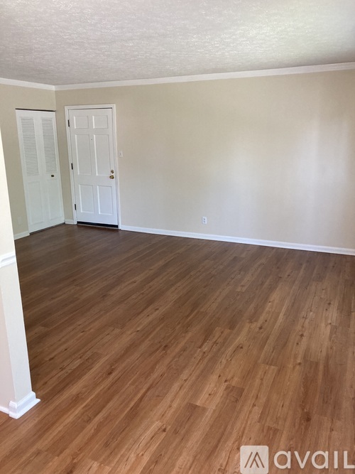 A room with wooden flooring and a white door.