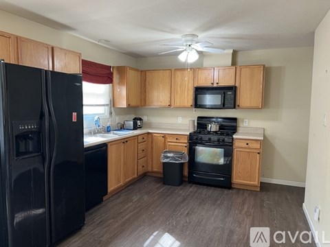 A kitchen with wooden cabinets and black appliances.