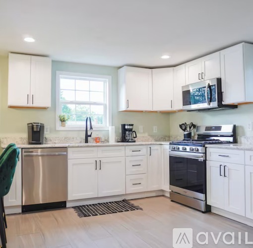 A kitchen with white cabinets and a stainless steel dishwasher.