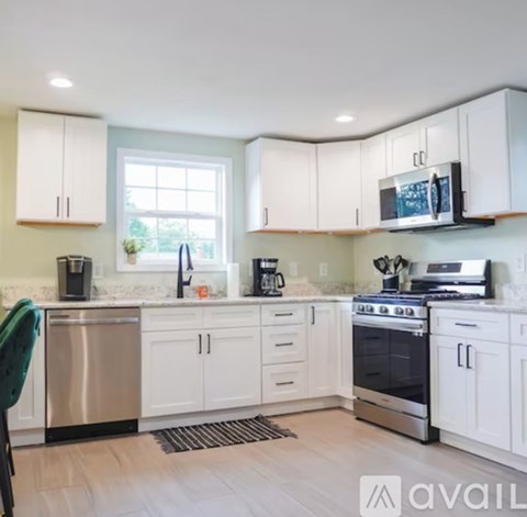 A kitchen with white cabinets and a stainless steel dishwasher.