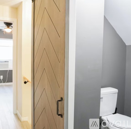 A wooden door with a black handle is closed.