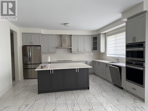 A kitchen with a refrigerator, oven, and sink.