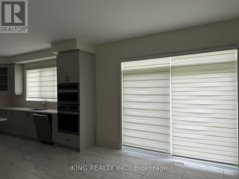 A kitchen with white blinds on the window.