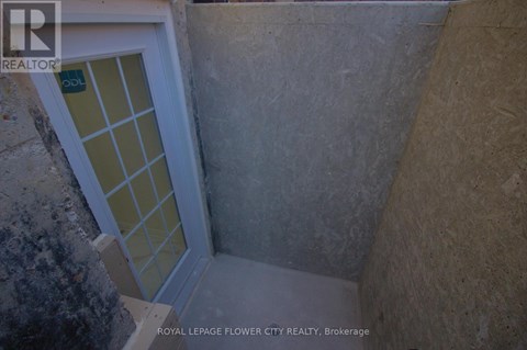 A door with a glass window in a concrete room.