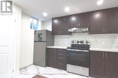 A kitchen with dark wood cabinets and a marble countertop.