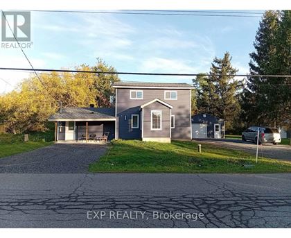 A house with a grey roof and a blue garage door is for sale.