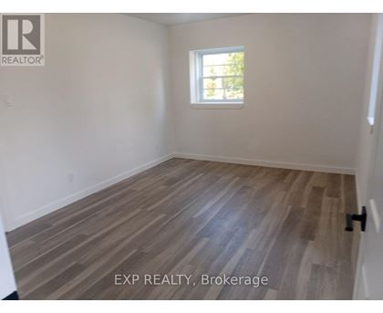 A room with wooden flooring and a window.