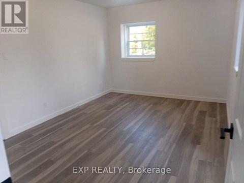 A room with wooden flooring and a window.