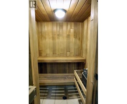 A wooden sauna with a bench and a heater.