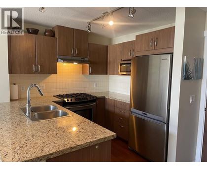 A kitchen with a granite countertop and stainless steel appliances.