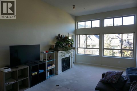 A living room with a fireplace and a television.