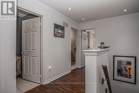 A realtor photo of a house interior with a white door and a framed picture on the wall.
