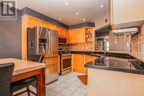 A kitchen with wooden cabinets and a black countertop.