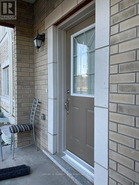 A grey door is on a brick wall.