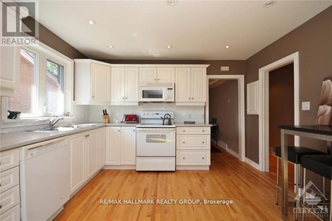 A kitchen with white appliances and cabinets.