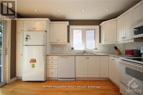 A clean, white kitchen with a refrigerator and cabinets.