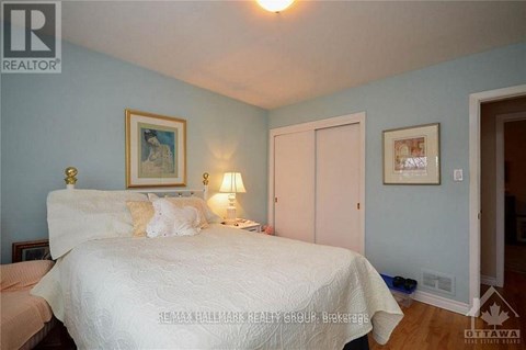 A bedroom with a bed, nightstand, and lamp.