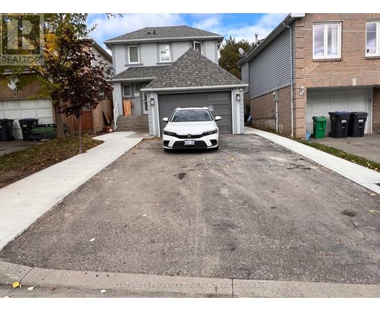 A white car is parked in a driveway.
