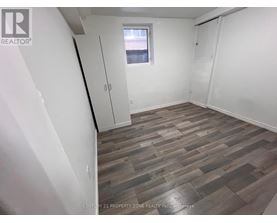 A room with wooden flooring and white walls.