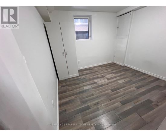A room with wooden flooring and white walls.