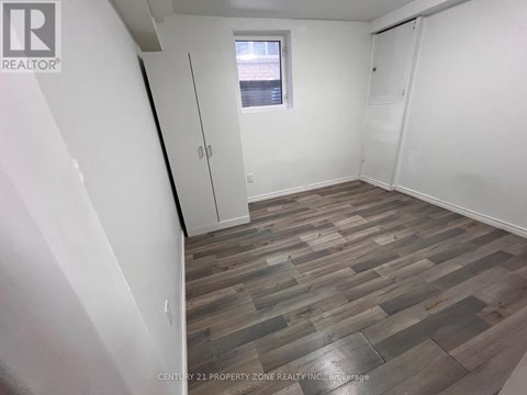 A room with wooden flooring and white walls.