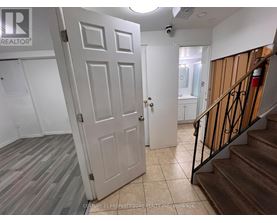 A white door is open to a hallway with a staircase on the right.