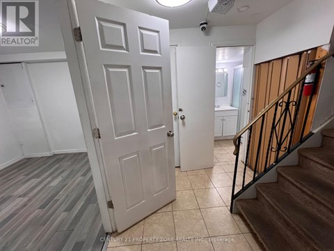 A white door is open to a hallway with a staircase on the right.