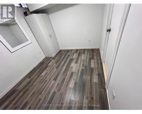 A room with wooden flooring and white walls.