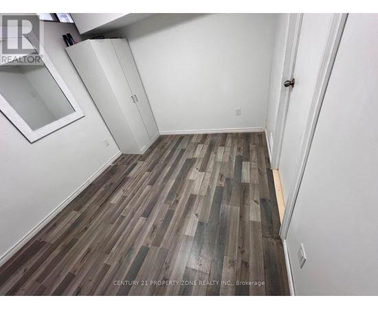 A room with wooden flooring and white walls.