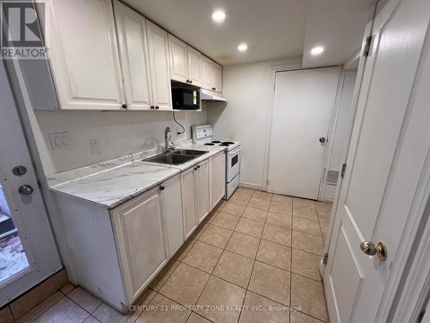 A kitchen with white cabinets and appliances.