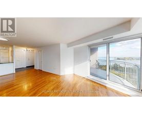 A spacious room with wooden floors and a view of a bridge through the window.