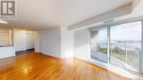 A spacious room with wooden floors and a view of a bridge through the window.