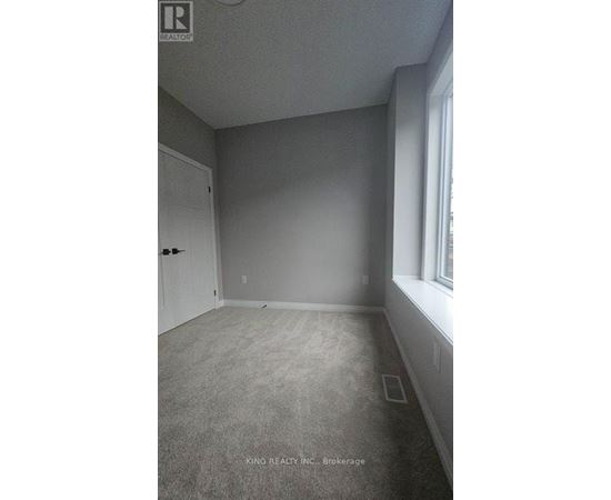 A room with a door and a window, with a carpet on the floor.