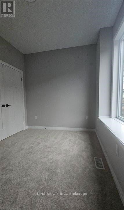 A room with a door and a window, with a carpet on the floor.