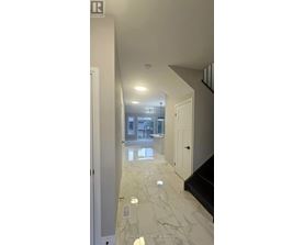 A hallway with marble flooring and white walls.