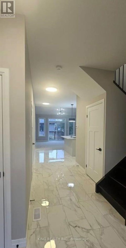 A hallway with marble flooring and white walls.