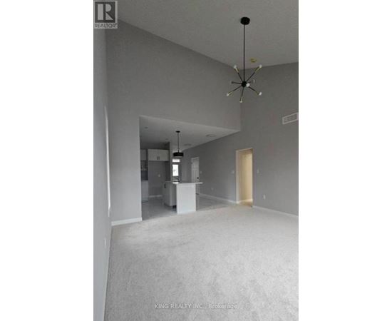 A spacious room with a chandelier and a white cabinet is on the market.