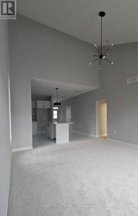 A spacious room with a chandelier and a white cabinet is on the market.