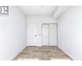A white bedroom with two doors and a wooden floor.
