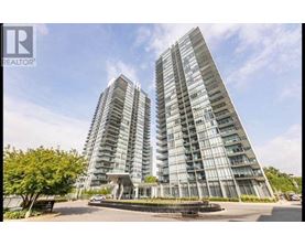 A tall residential building with a glass facade stands under a clear blue sky.