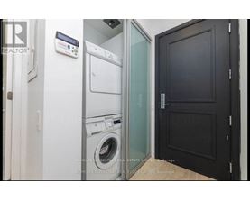 A laundry room with a washer and dryer stacked on top of each other.