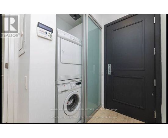 A laundry room with a washer and dryer stacked on top of each other.