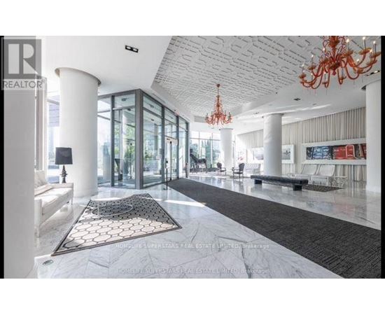 A large, open living space with a chandelier and a long hallway.